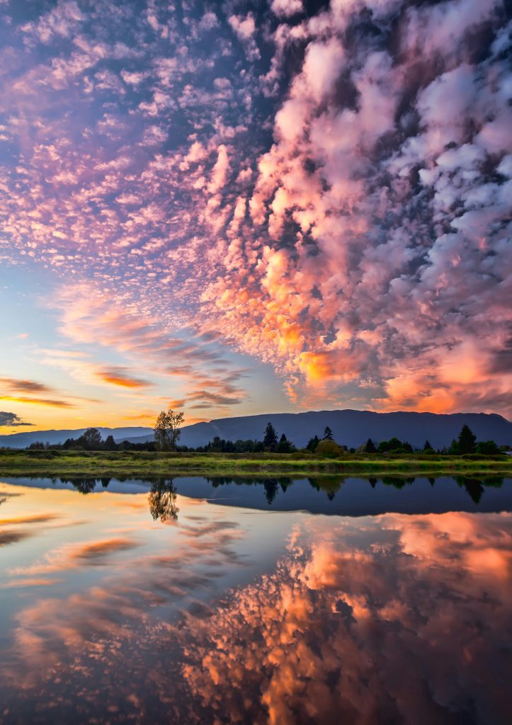L'accompagnement Captivating sunset with vibrant clouds and serene reflections over Pitt Meadows, BC.