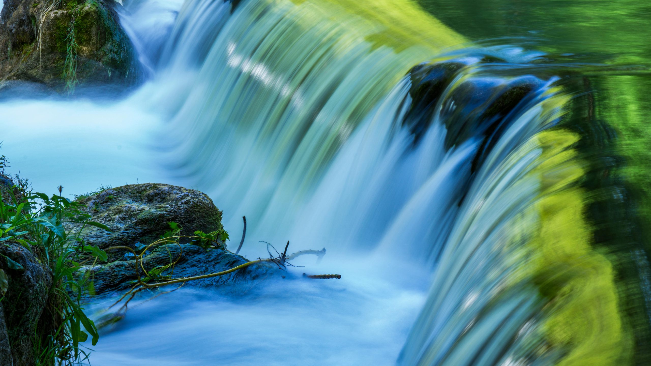A serene waterfall cascading over mossy rocks in Munich, Germany.